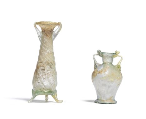  A Roman green glass amphoriskos and a Roman green glass balsamarium  Circa 1st-4th Century A.D.The amphoriskos with one gree