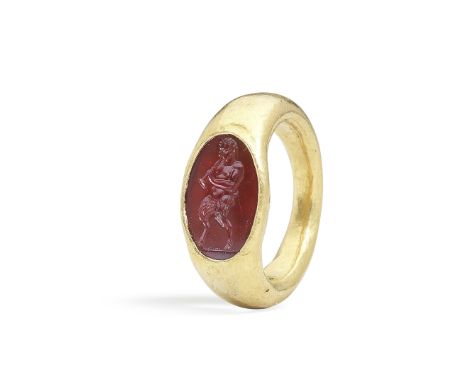  A Roman gold and carnelian intaglio ring with Pan Circa 1st Century A.D.The hollow gold hoop set with an oval intaglio engra