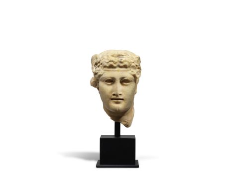  A Roman giallo antico marble herm head of Dionysus Circa 1st-2nd Century A.D.The wavy hair dressed with a fillet and garland