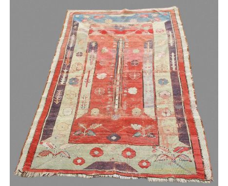 MELAS RUG, WEST ANATOLIA, the abrashed crimson field with central column and flower heads enclosed by flower head borders, 17