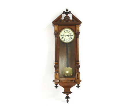 A late 19th century Austrian walnut cased wall clock, with architectural case, break arch pediment and column sides. An ivori
