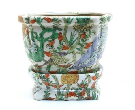 A Chinese porcelain planter on stand, 20th century, painted in enamels with birds among foliage, each bearing a six character