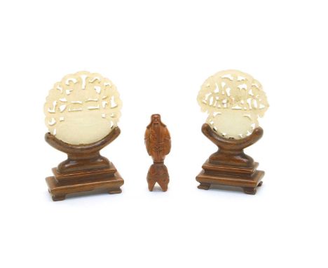 Two Jade and pierced plaques, 20th century, each in the form of a flowering plant within a jardiniere, wood stands, and carve