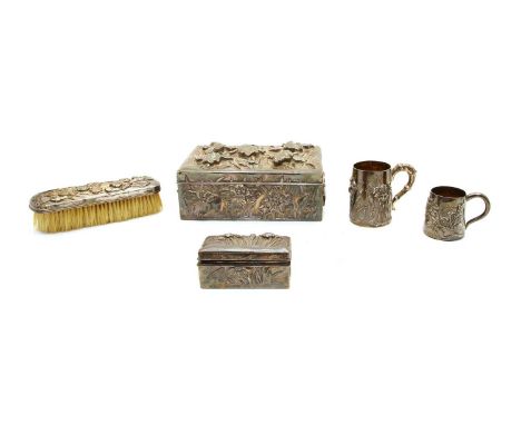 Five Japanese silver items: the first a box, tests silver, heavily embossed with irises, base inscribed 'Kuhn &amp; Komor' 20