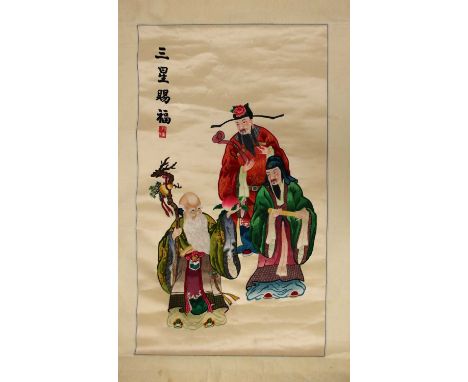 A Chinese embroidered hanging scroll, 20th century, of Fu, Lu and Shou, inscribed San Xing Ci Fu, 97x59cmCondition report: cr