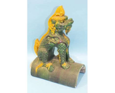 A Chinese ridge tile in the form of a dog, in ochre and green-glazed colours, 37cm high.