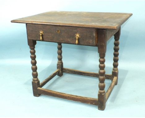 An antique oak side table, the rectangular top above a drawer, on bobbin-turned legs joined by stretchers, 78cm wide, 64cm hi