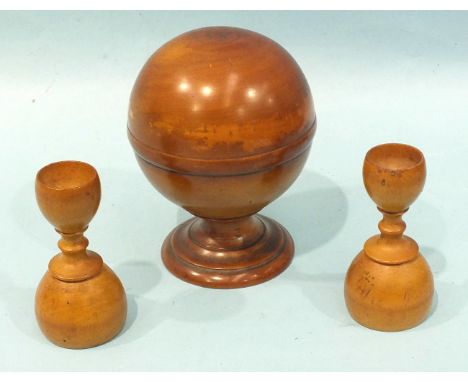 A 20th century polished boxwood pill roller of spherical form raised on a plinth, stamped S Maw &amp; Son, 10cm high, 8cm dia