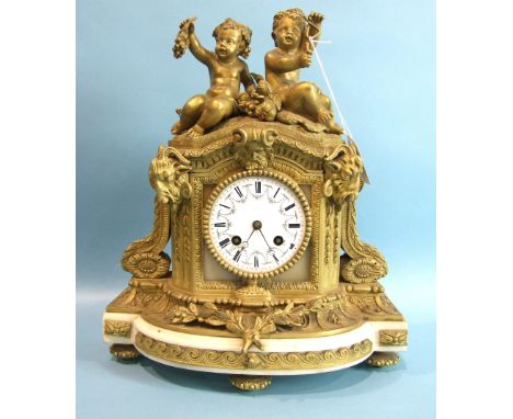 A 19th century French ormolu and alabaster mantel clock, the arched case surmounted by two bacchantes and cast with ram's hea