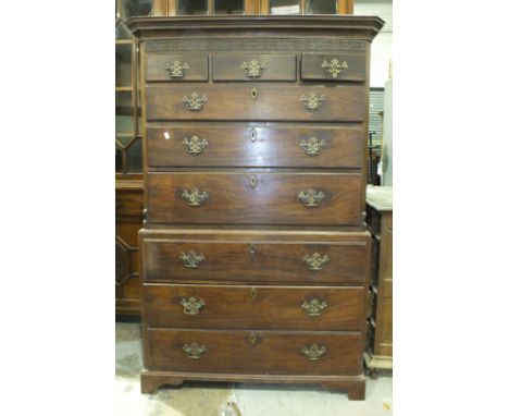 A Georgian mahogany chest on chest, the cornice and blind fret frieze above three small and six long drawers, on bracket feet