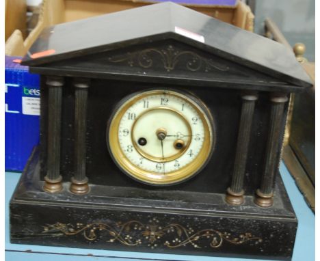 An Edwardian black slate mantel clock of architectural form having an enamel dial with Arabic numerals and eight day movement