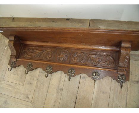 Oak carved wall shelf with embossed cherub coat hooks (width 102cm)