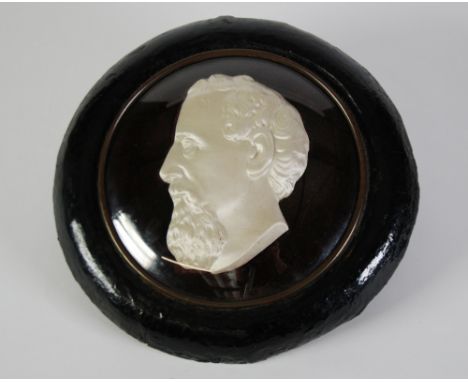 PAIR OF LATE NINETEENTH CENTURY EMBOSSED AND SILK CLAD CIRCULAR PORTRAIT PLAQUES, of a man and woman in glazed black papier m
