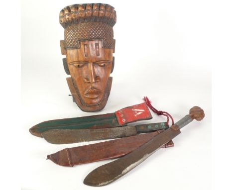 CARVED WOOD TRIBAL MASK, 18" (45.7cm) long, A MACHETE WITH CARVED WOOD FIGURAL POMEL AND LEATHER SHEAF stamped 'Trinidad' AND