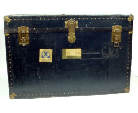 EARLY TWENTIETH CENTURY GILT METAL MOUNTED LARGE TRAVELLING TRUNK with Cunard White Star sticky labels and leather side carry