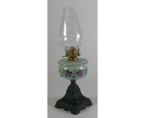 VICTORIAN CAST IRON AND FLORAL PAINTED OPAQUE GLASS OIL TABLE LAMP, typical form with clear glass chimney/shade, 20" (50.8cm)