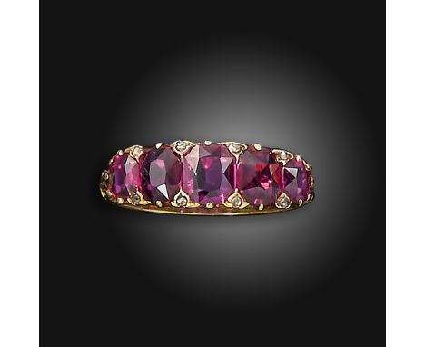 A late Victorian ruby five-stone ring, set with graduated cushion-shaped rubies, with rose-cut diamond pointers, with scroll 