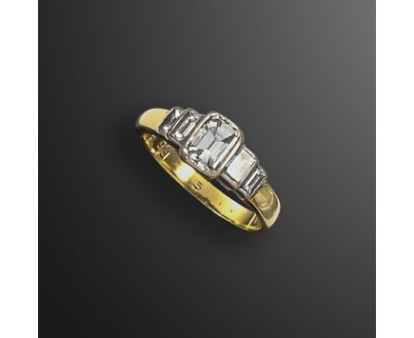 A diamond-set 18ct gold ring, the central emerald-cut diamond flanked to either side by two graduated step-cut diamonds, hall