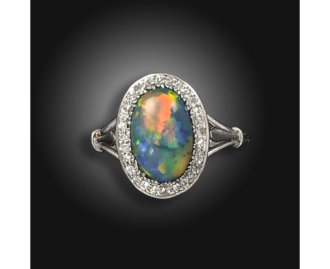 An early 20th century opal and diamond cluster ring, the opal cabochon set within a surround of single-cut diamonds in platin