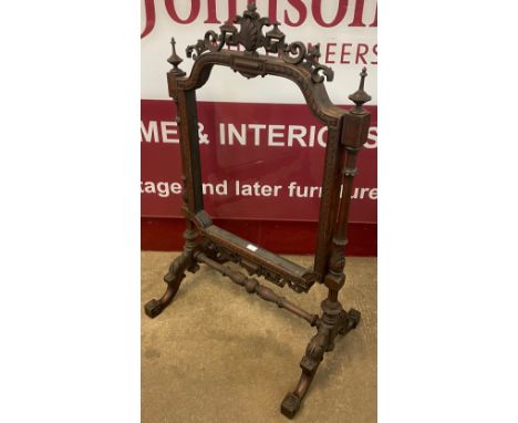 A Victorian carved mahogany fire screen, lacking insert