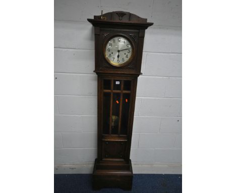 A 20TH CENTURY OAK GRANDFATHER CLOCK, the hood fitted with a circular convex glass door, that's enclosing a 9.5 inch brass an