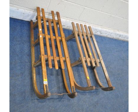 TWO WOODEN SLEDGES, with slatted seats, largest length 113cm (condition report: largest sledge with losses and repairs, other