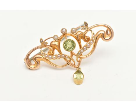AN EARLY 20TH CENTURY BROOCH, a yellow metal scrolling design brooch set with seed pearls, a central circular cut peridot, fi