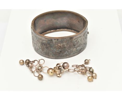 A WIDE BANGLE AND A PAIR OF EARRINGS, the bangle with engraved floral and foliate decoration to the push piece clasp, togethe