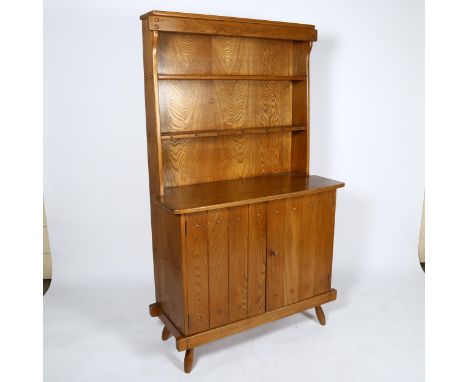 A mid-century brutalist oak dresser by F Co, the plate rack over 2 door cupboard with interior drawer, inset maker?s label to