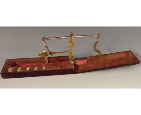 A George III mahogany folding sovereign balance, brass and steel scales with weights en-suite, 14cm wide (folded), c.1800 