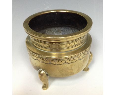 A Chinese sensor, in relief with bands of clouds, the neck with fretwork band, three scroll feet, 9cm diam,  Ming marks