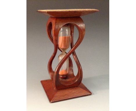 Treen - an unusual mahogany egg timer, the glass cistern within a helix, spreading square base and cresting, 11.5cm high, ear