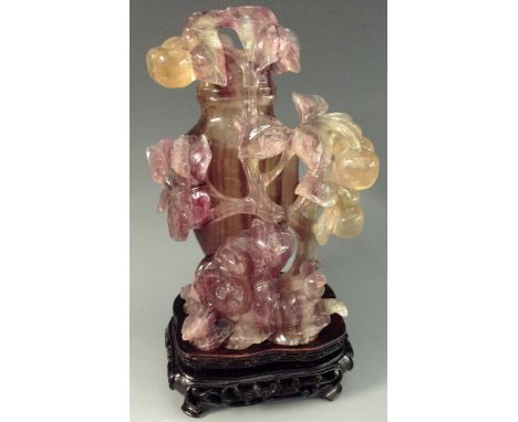 A Chinese lapidary fluorspar bottle and cover, in tones of purple and green, carved with two cats playing at the foot of a ch