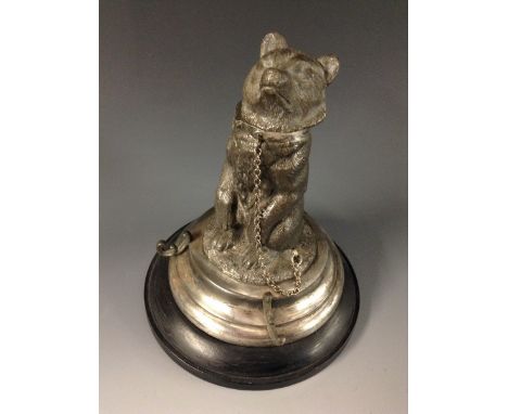 A 19th century German silver plated Black Forest inkwell, cast with a chained bear sitting on a grassy ground, circular base 