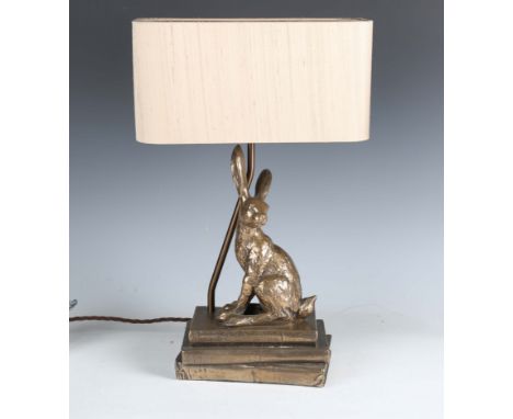 A modern David Hunt bronzed resin table lamp, the support modelled as a hare seated on three books, fitted with a taupe silk 