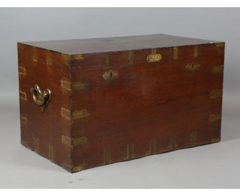 A mid-19th century teak and brass bound travelling trunk, the lid inset with a plaque detailed 'J.B. Clement 1863 East Indies
