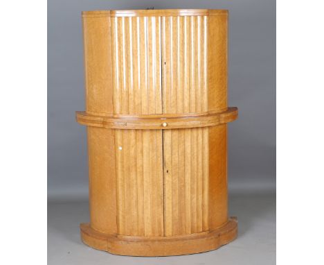 An Art Deco bird's eye maple drinks cabinet of demi-lune form, fitted with four fluted doors and a pull-out slide, the top in