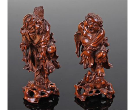 Two 19th Century carved figures, the first standing on a toad with carved gourds to his back, the second with a bat in one ha