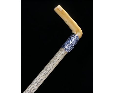 Victorian marine ivory stick, the marine ivory handle with white metal collar decorated with foliage and trophies of war one 