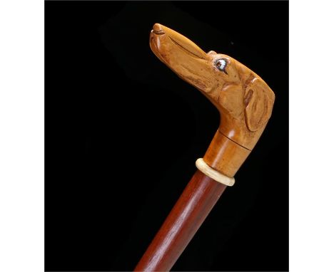 Walking stick with greyhound head handle, the head inlaid with glass eyes with ivory collar and brass ferrule. Length 98cm