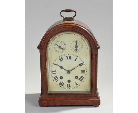 Early 20th Century oak mantel clock, the swing handle above the arched case, silvered dial with Roman hours, slow/fast and ch