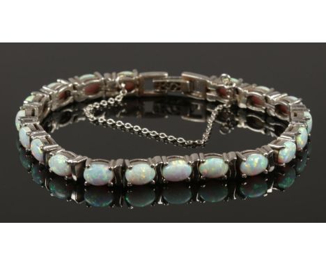 A silver and opal line bracelet with safety chain.  