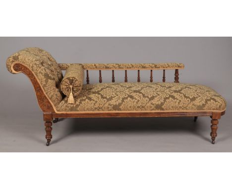 A Victorian mahogany chaise lounge. With deep button upholstery and turned supports.  