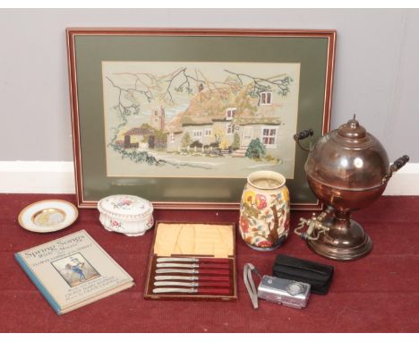 A box of miscellaneous. Includes framed needlework, samovar, Spring Songs book, digital camera etc.  