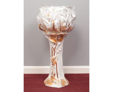 A ceramic Jardinière plant stand. Decorated with leaves and flowers in white and gold. H:  71cm, W: 33.5cm.  Condition good. 