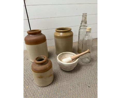 Three stoneware jars and two vintage glass bottles