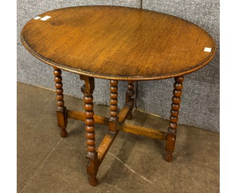 An early 20th Century oak bobbin turned tilt top occasional table 