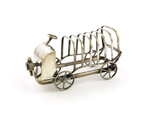 An electroplated novelty seven-bar toast rack, marked E.P.N.S, no maker's mark, formed as a vintage car, the front with a lam