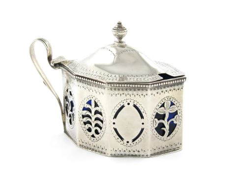 A George III silver mustard pot, by Hester Bateman, London 1786, oval panelled form, reeded scroll handle, domed hinged cover