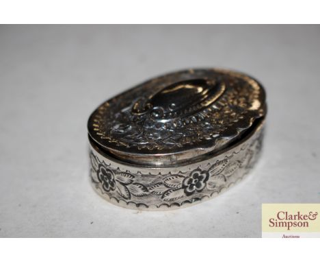A small oval silver hinged patch box